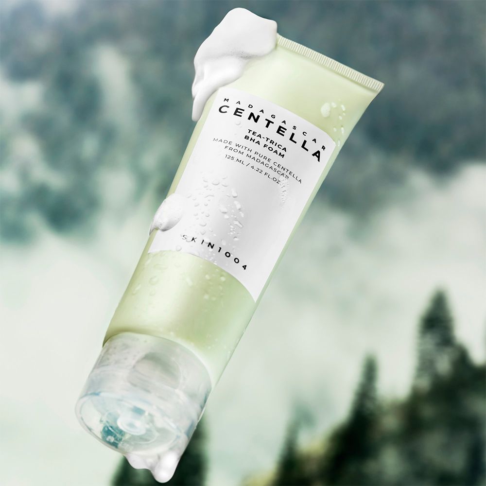 Tubo verde con schiuma e gocce d'acqua, fluttuante su sfondo sfocato.