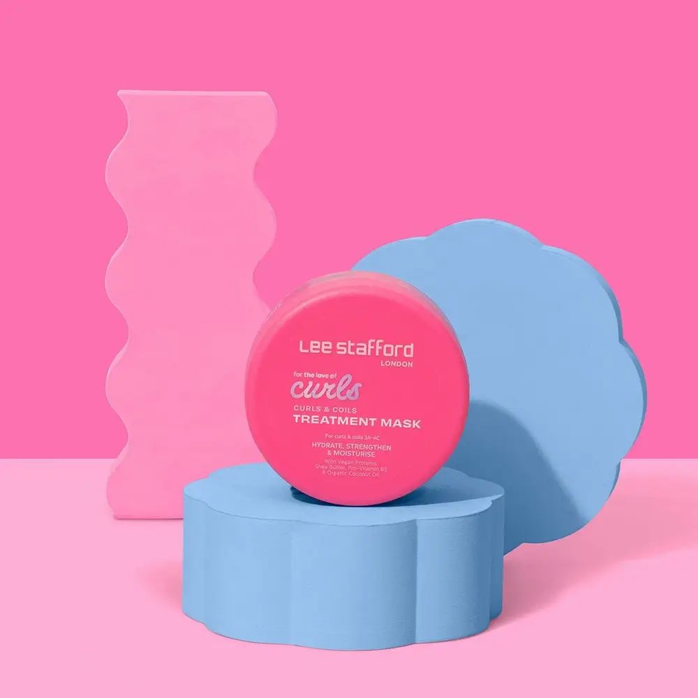 Vasetto rotondo rosa di maschera per ricci su piedistallo blu. Sfondo: elementi rosa e blu.