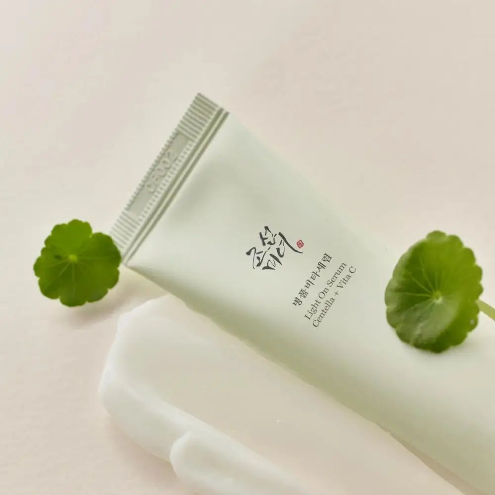 Prodotto e foglie. Scritta: Light on Serum Centella + Vita C. Marchio: BEAUTY OF JOSEON. Crema accanto.