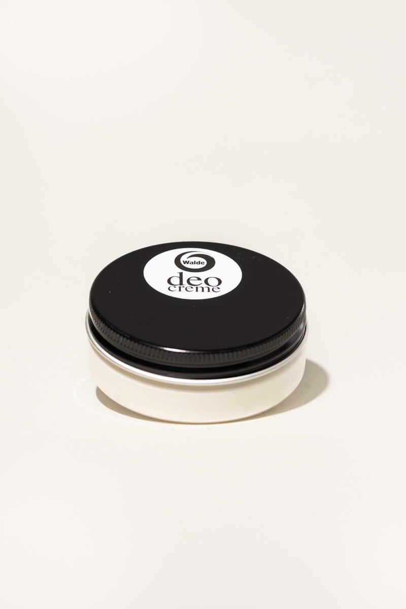 Barattolo di crema con coperchio nero e contenitore bianco. Sulla parte superiore, etichetta bianca con "deo creme".