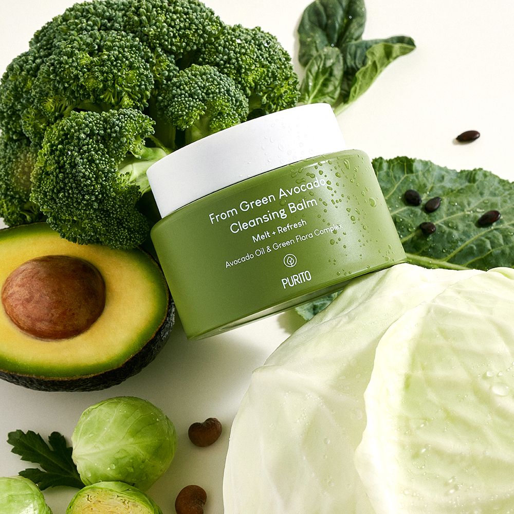 Vasetto verde circondato da broccoli, mezzo avocado e cavolo.
