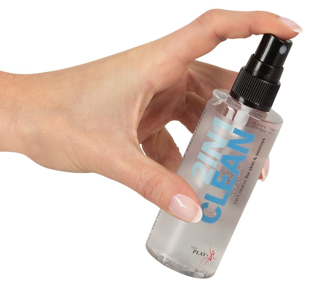 Mano che tiene un flacone spray detergente 2 in 1 per pelle e giocattoli.