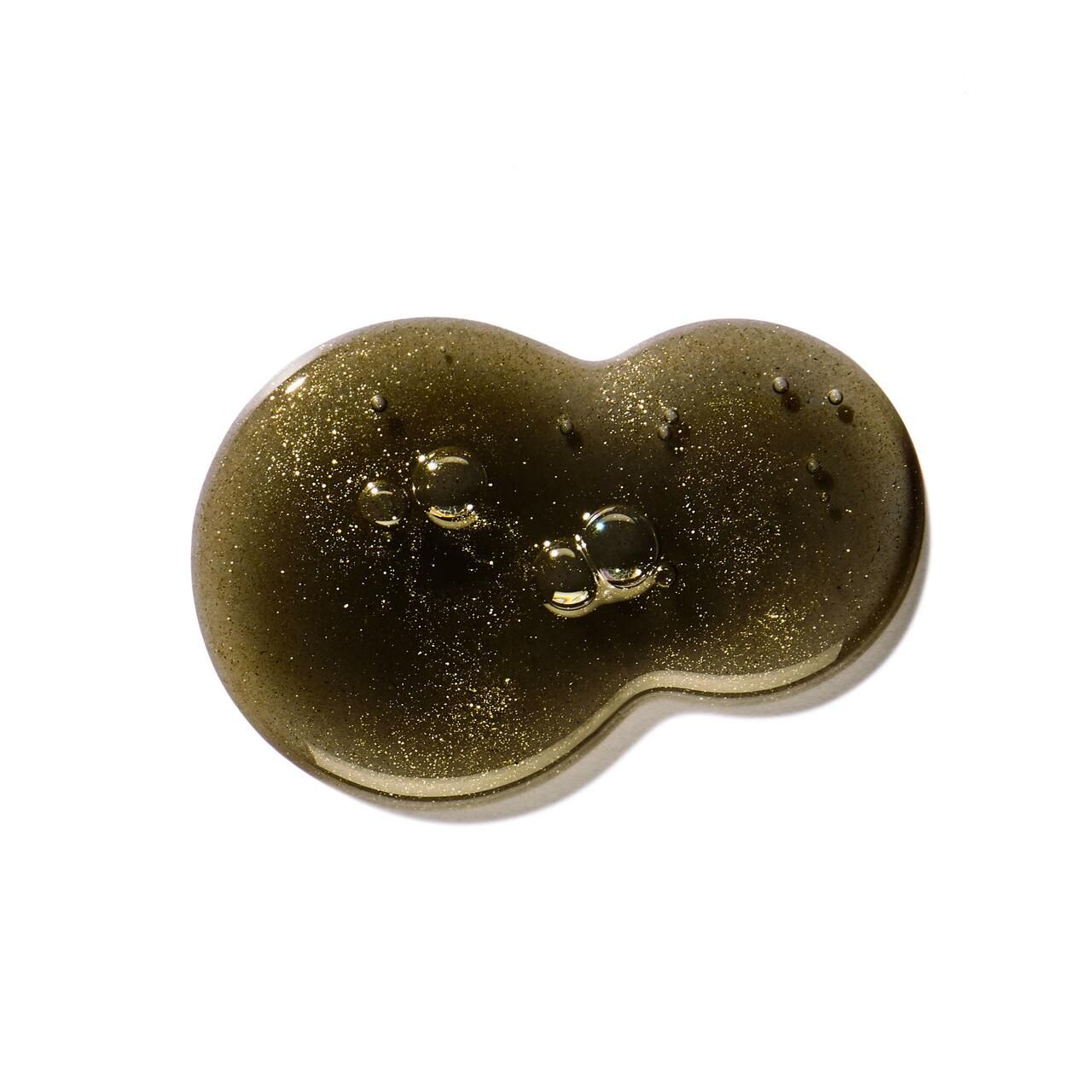 Goccia di gel doccia con glitter dorati. Tonalità: verde scuro. Su sfondo bianco.