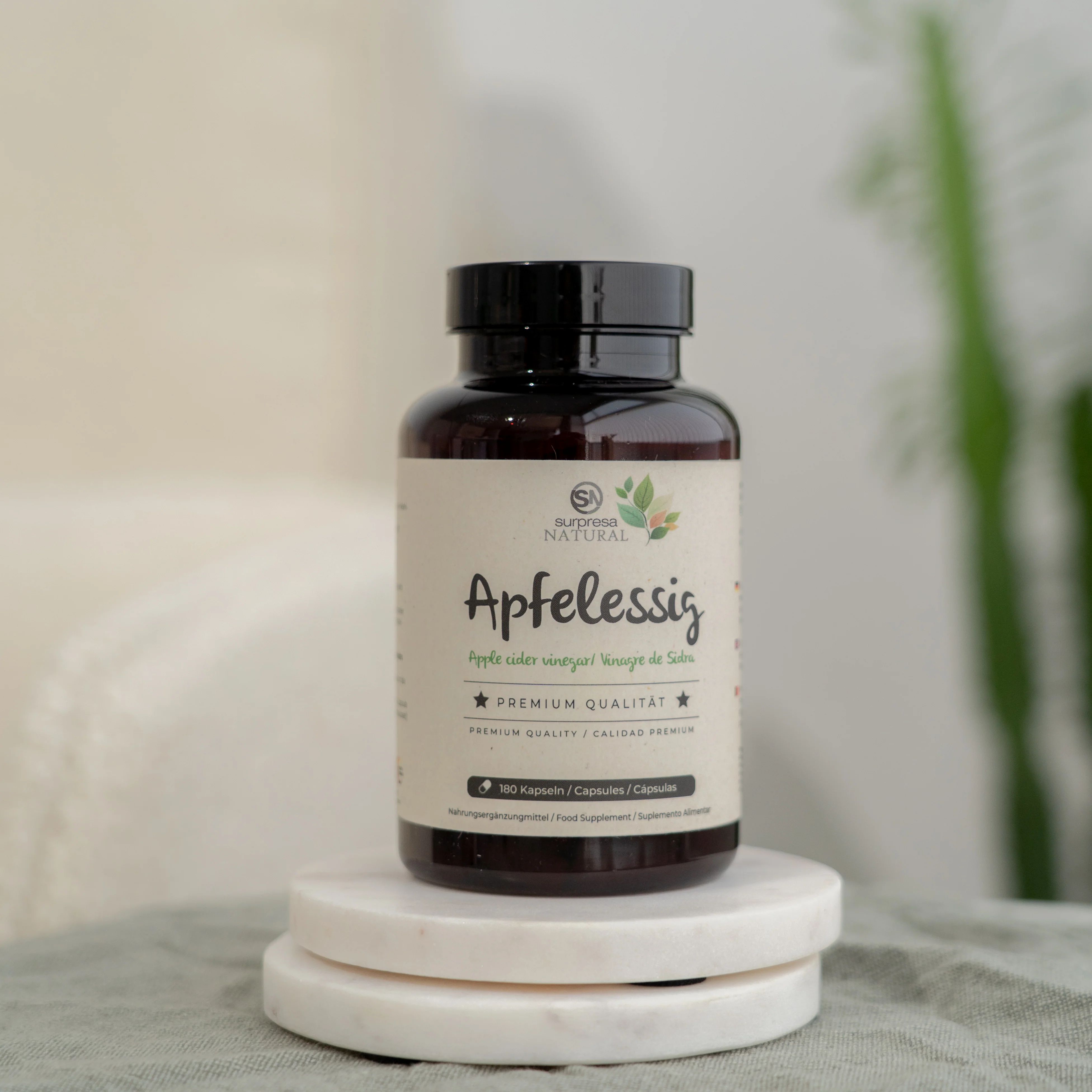 Bottiglia marrone con tappo nero. Scritta: Aceto di mele. Su sfondo bianco.