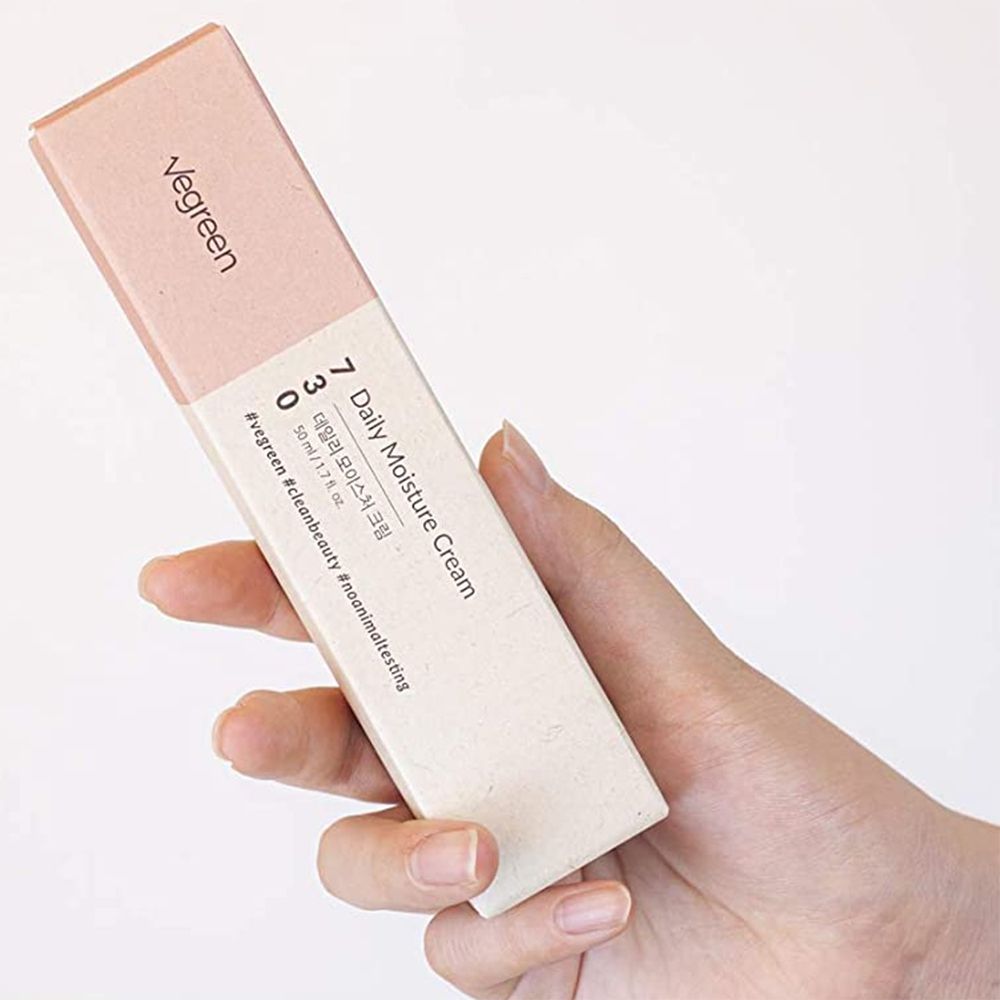 Confezione prodotto 'Vegreen 730 Daily Moisture Cream' in mano. Scatola rosa-beige con informazioni.