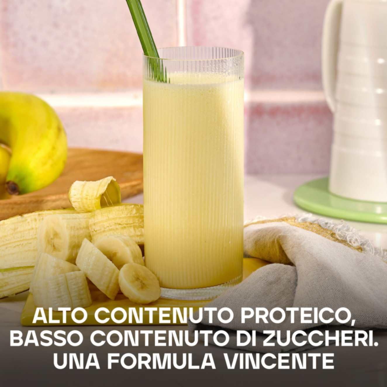 Bicchiere con bevanda gialla, banane e testo: ALTO CONTENUTO PROTEICO, BASSO ZUCCHERI. Una formula.