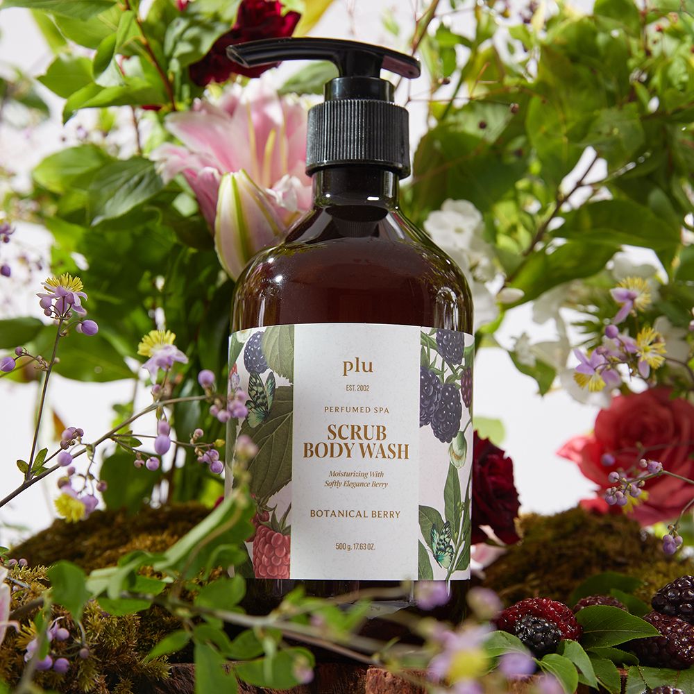 Flacone marrone con dosatore nero. Etichetta con nome del prodotto e illustrazioni floreali. Circondato da fiori e bacche.