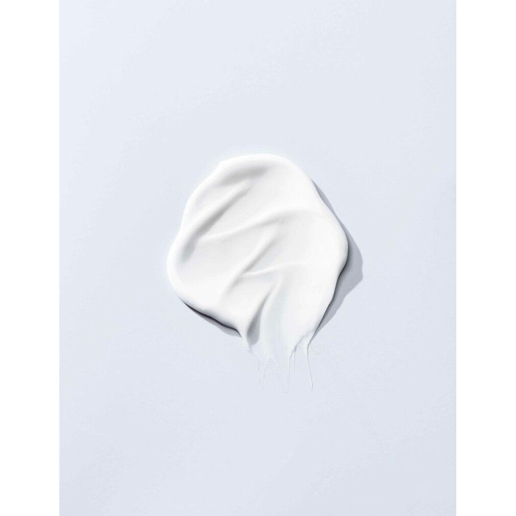 Macchia di balsamo bianco su sfondo chiaro. Consistenza cremosa. Superficie liscia con ombra.