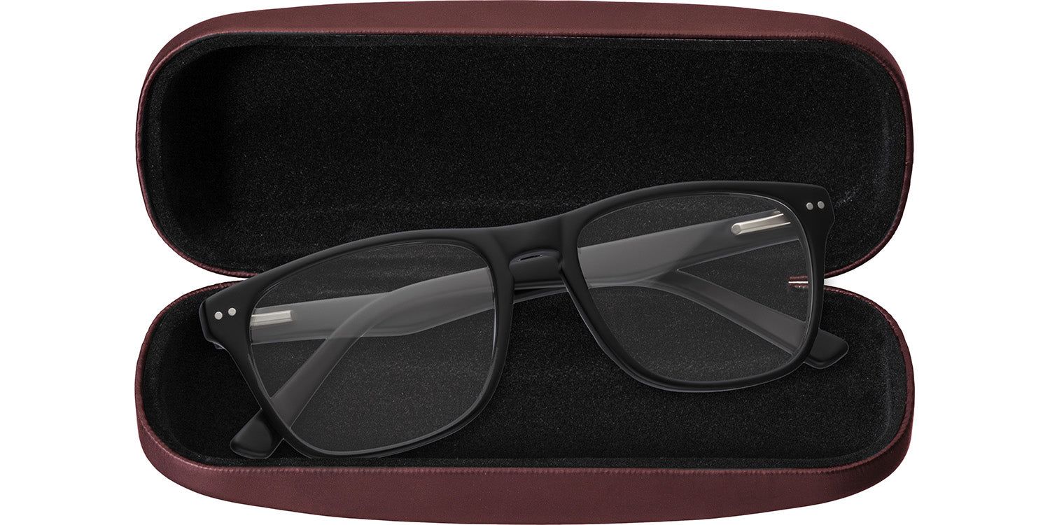 Astuccio rigido bordeaux aperto. Contiene occhiali neri con lenti trasparenti.