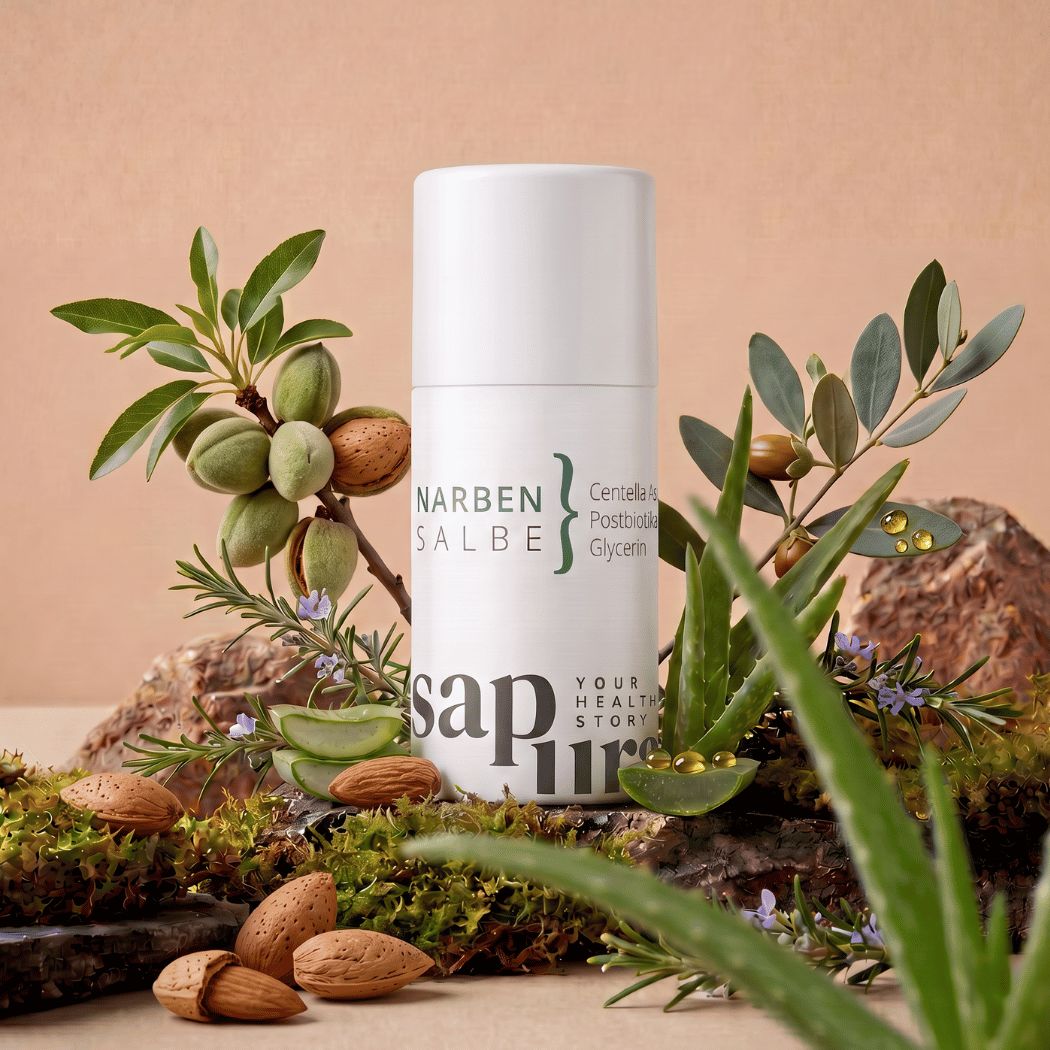 Flacone bianco con pompa 'Narbensalbe' circondato da aloe vera, mandorle ed erbe.