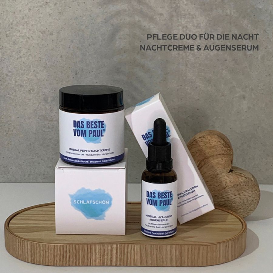 Due prodotti cosmetici su un vassoio di legno. Vasetto di crema, flacone di siero e due scatole. Testo: DAS BESTE VOM PAUL, Schlafschoen.