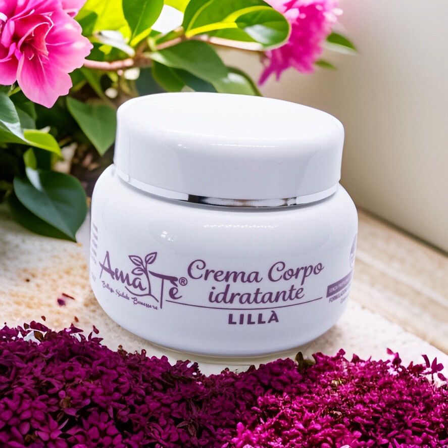 Vaso di crema bianco con coperchio. Scritta: Amatè Crema Corpo idratante Lillà. Circondato da fiori e foglie viola.