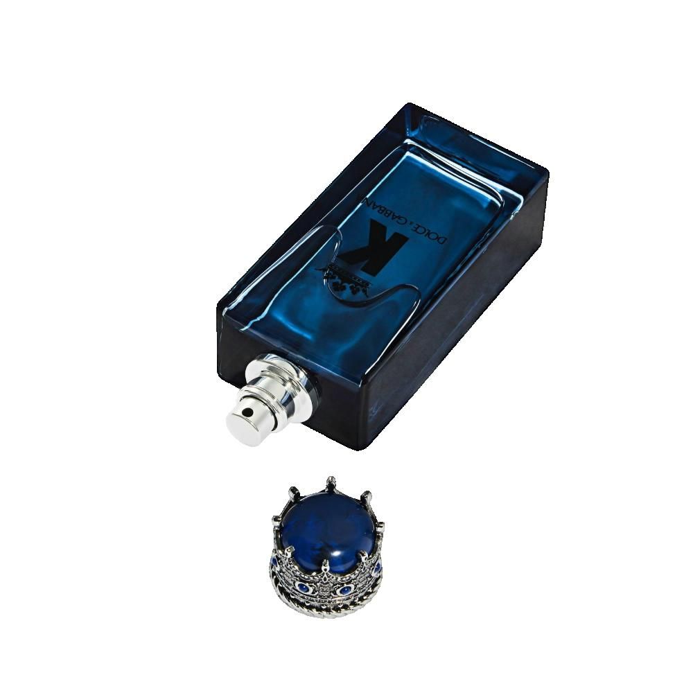 Flacone in vetro blu posato su un lato, con spruzzatore argentato e tappo a corona rimosso.