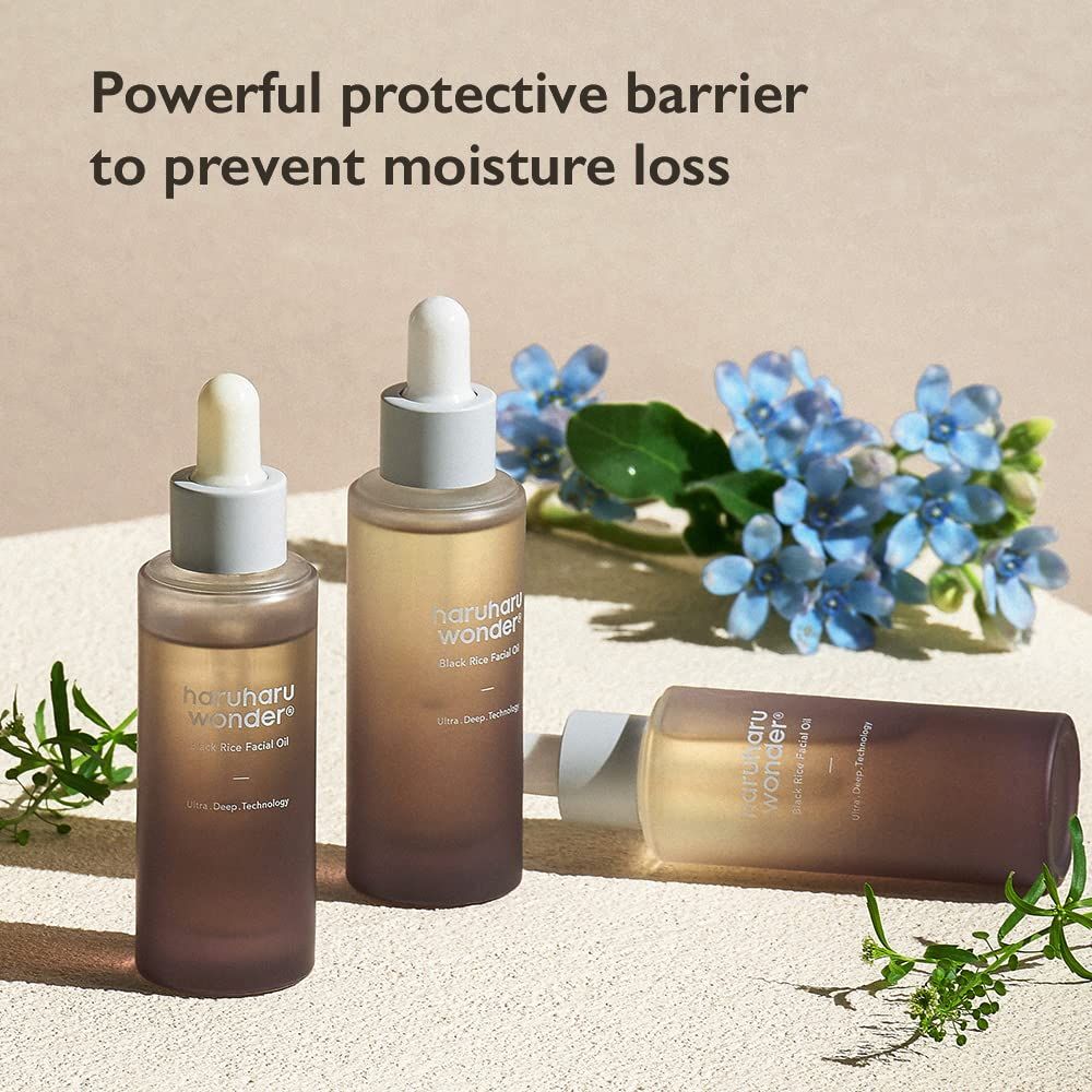 Tre flaconi di olio viso HaruHaru Wonder Black Rice. Due in piedi, uno sdraiato. Testo: Potente barriera protettiva, previene la perdita di umidità.
