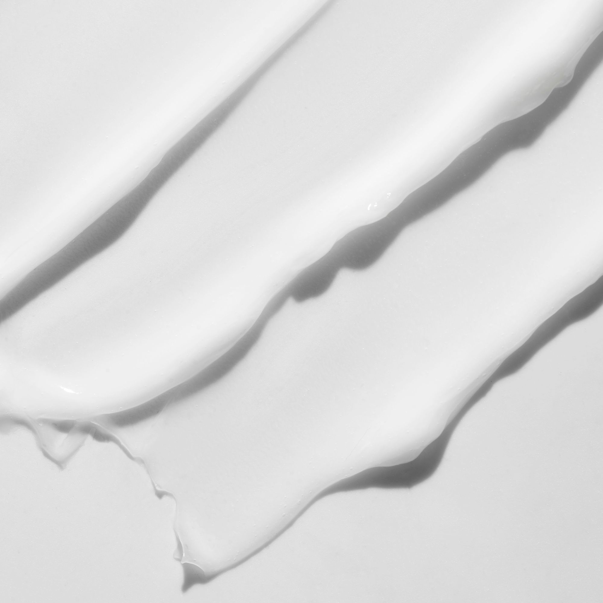 Primo piano di tre strisce di crema. Texture liscia con ombre.