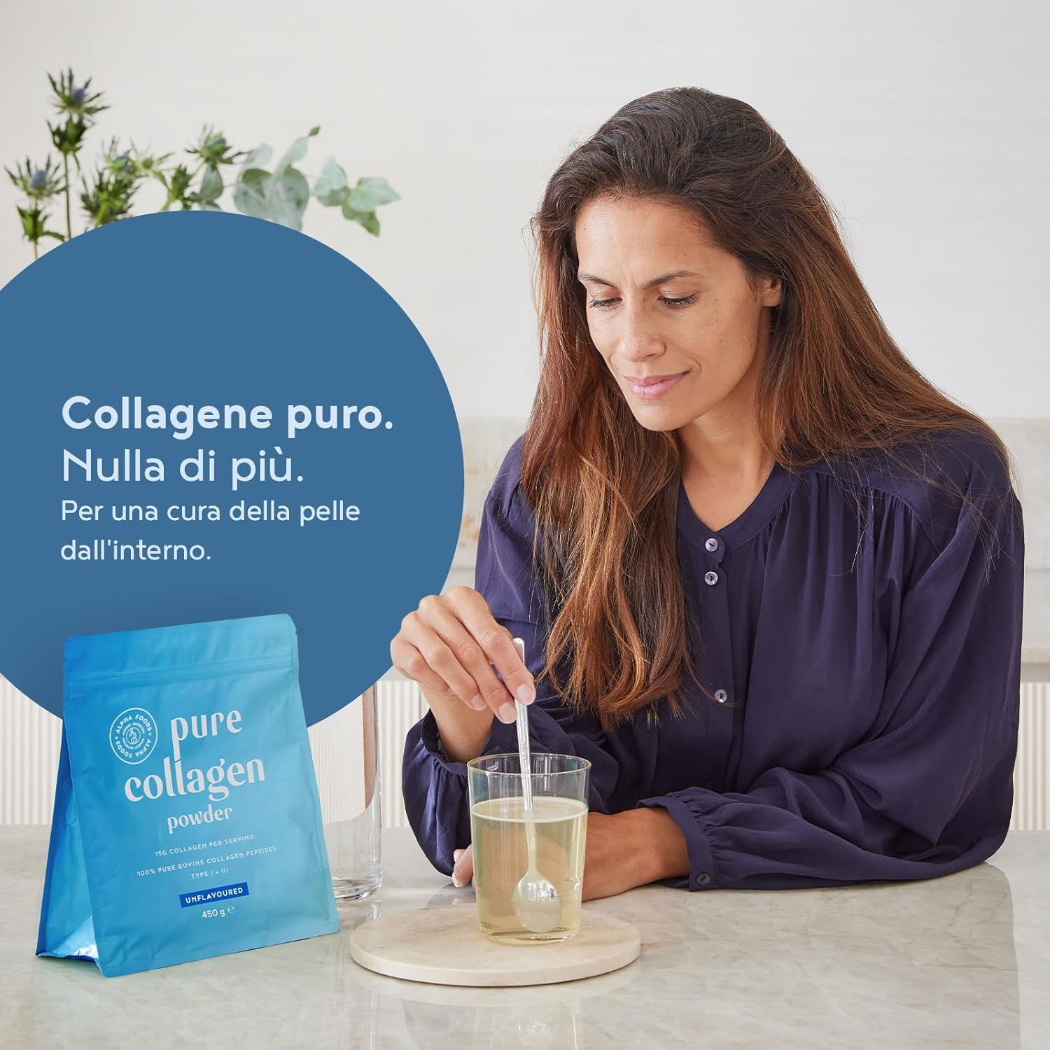 Donna mescola polvere di collagene in un bicchiere. Confezione blu sullo sfondo. Testo: Collagene puro. Niente di più.