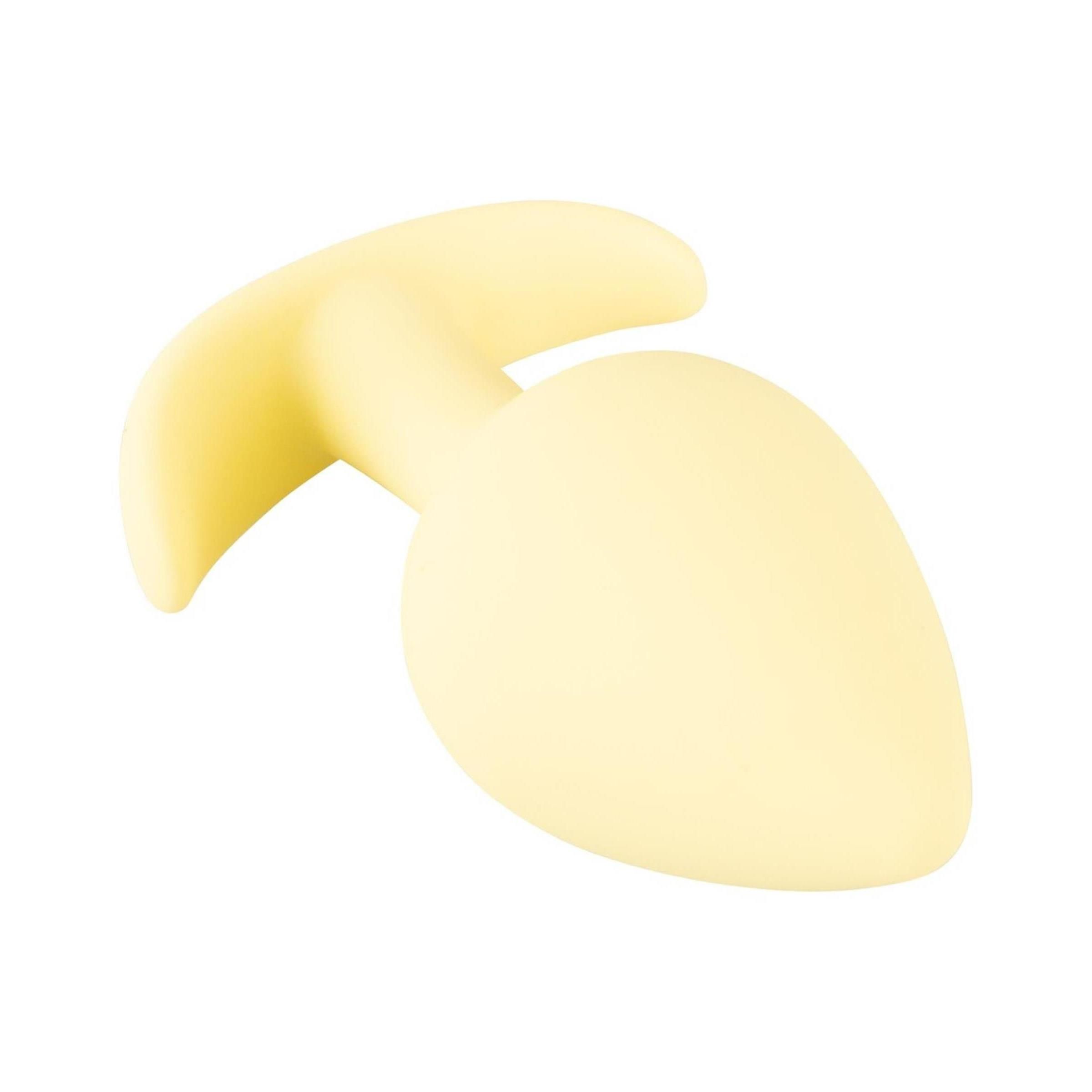 Plug anale giallo a forma di goccia, base curva. Realizzato in materiale morbido.