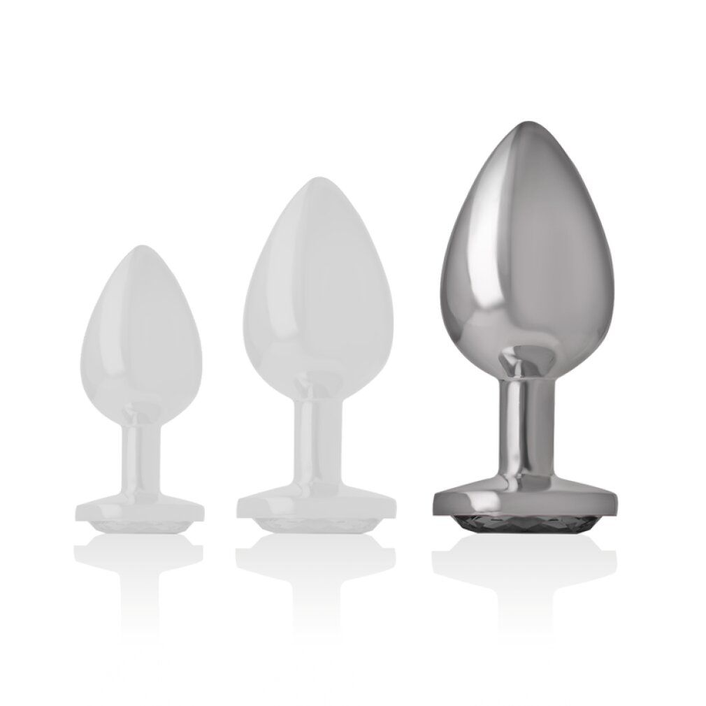 Confronto di tre plug anali in metallo di diverse dimensioni.
