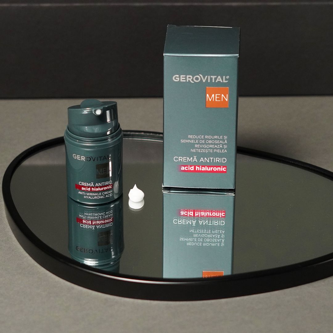 Flacone di crema verde scuro e scatola su uno specchio. Scritta: Gerovital MEN, Crema Antirid, Acid Hialuronic, Anti-Wrinkle Cream, Hyaluronic Acid.