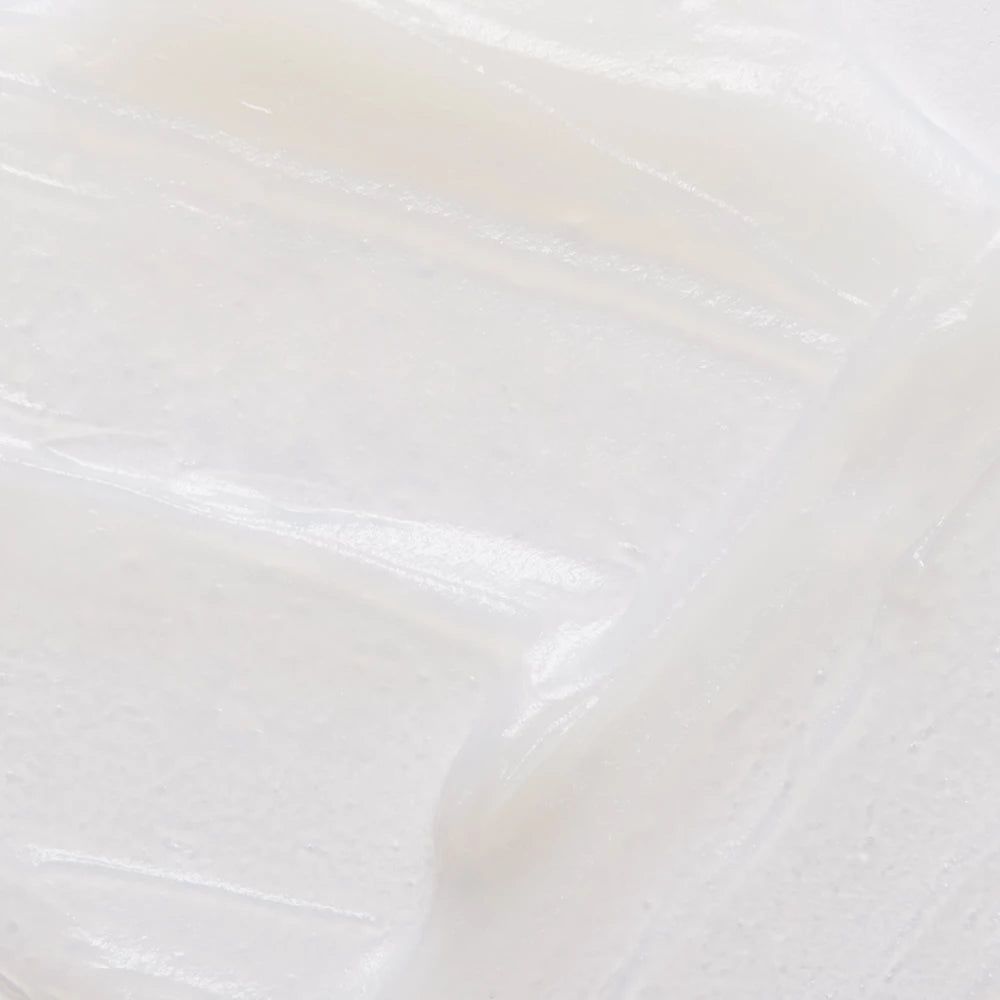 Prodotto bianco cremoso, primo piano. Superficie liscia e lucida con striature visibili.