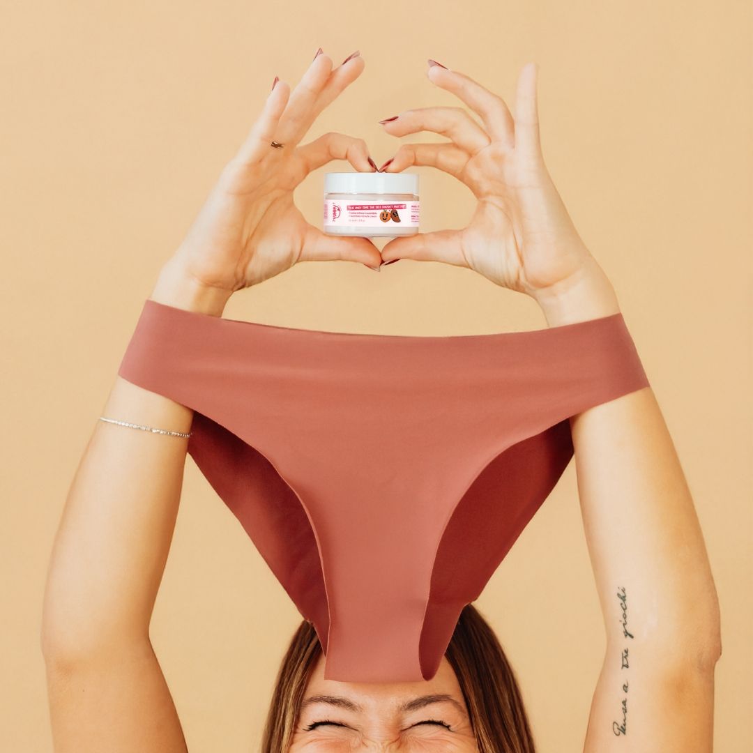 Persona che tiene un vasetto di crema e biancheria intima. Intimo rosa.