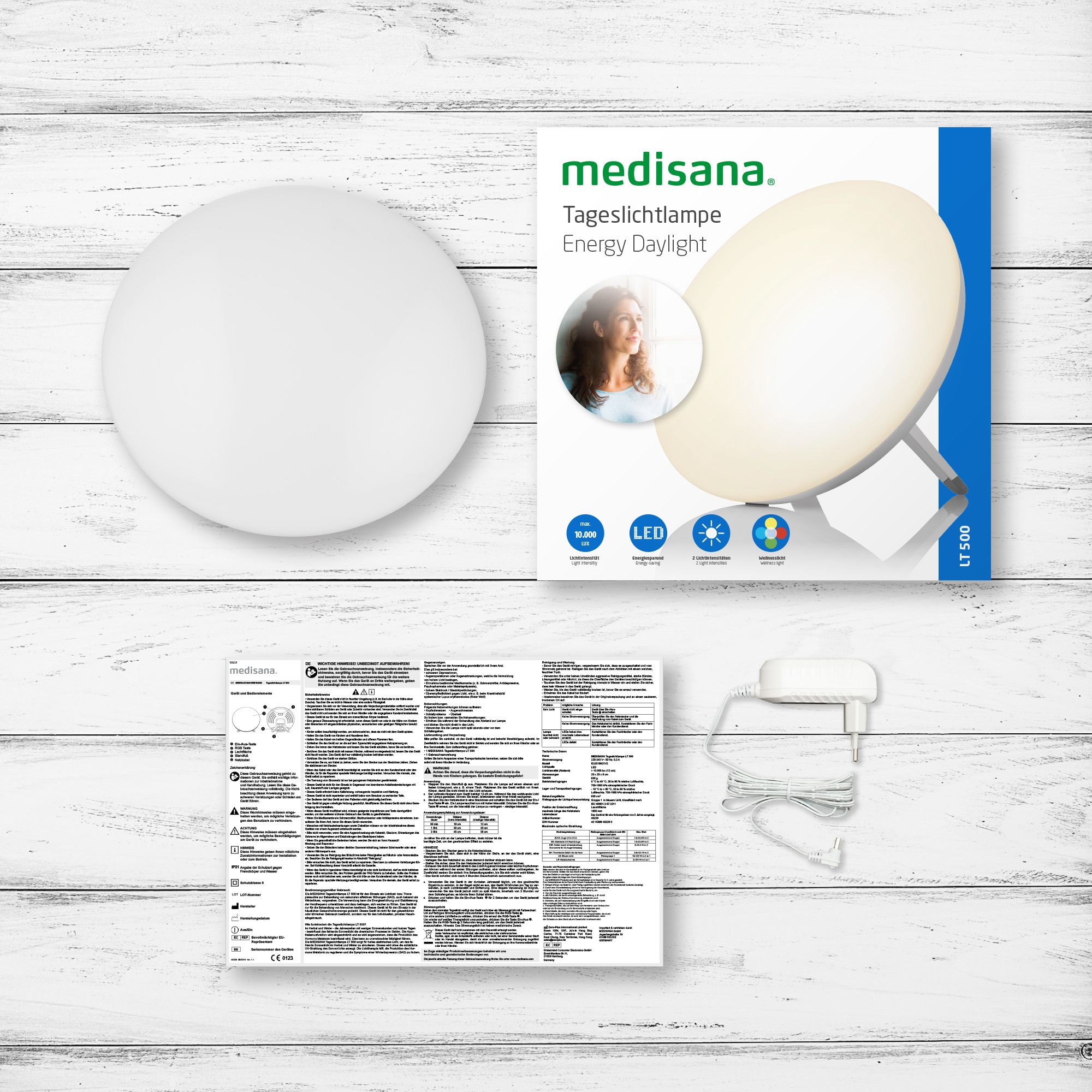 Confezione di una lampada per la luce diurna medisana con accessori: lampada, alimentatore, istruzioni.