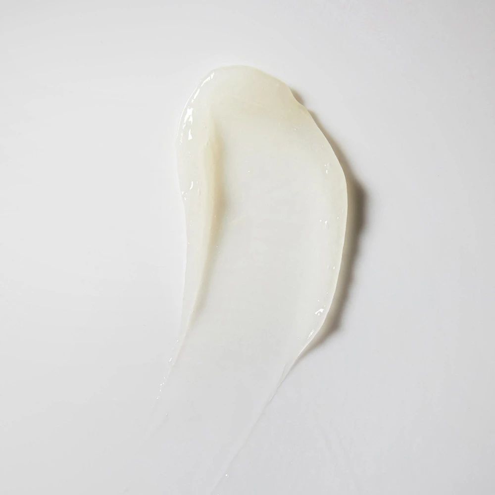 Campione di crema bianca su sfondo bianco. Forma: allungata, curva.