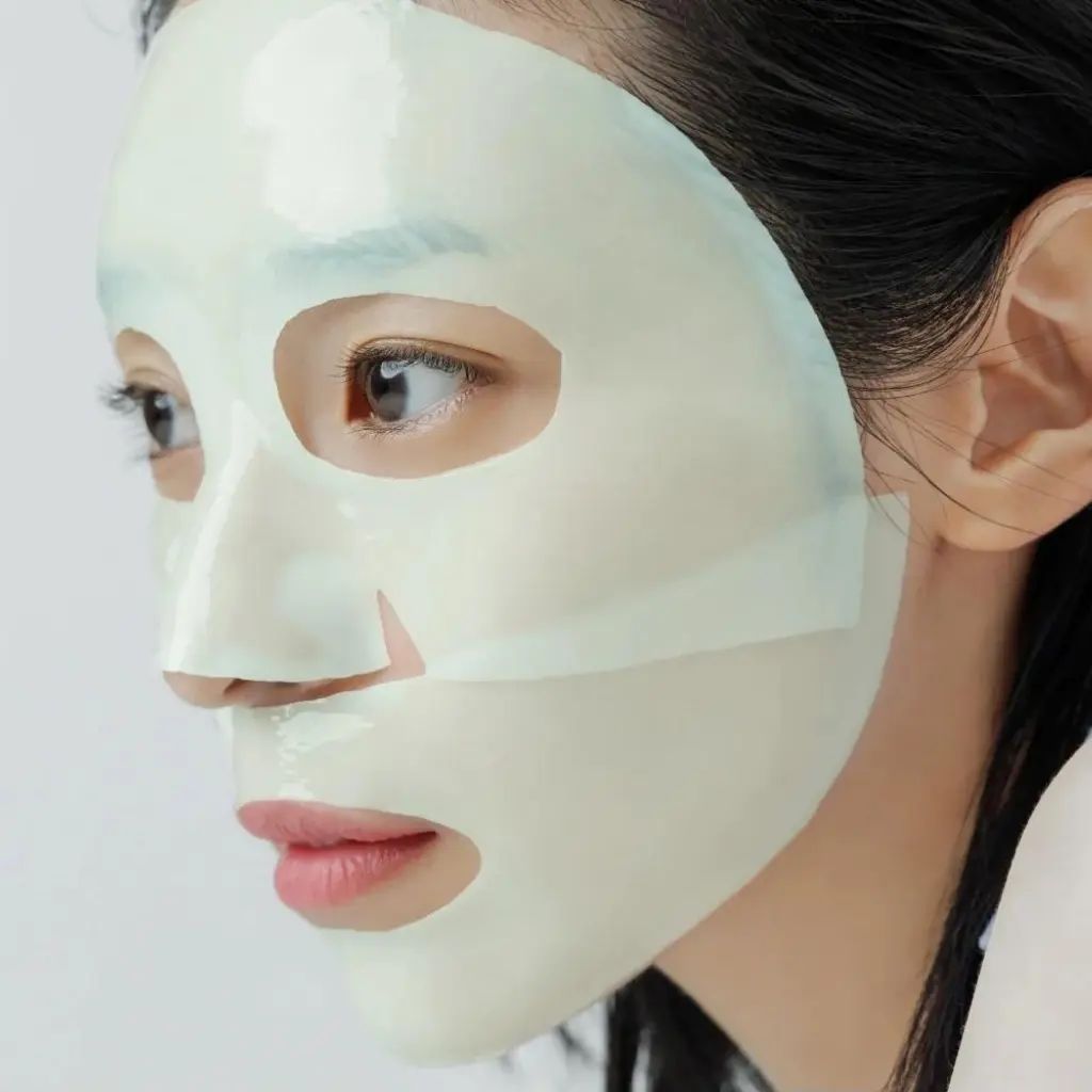 Viso di donna con maschera facciale applicata. La maschera copre il viso, occhi e labbra visibili.