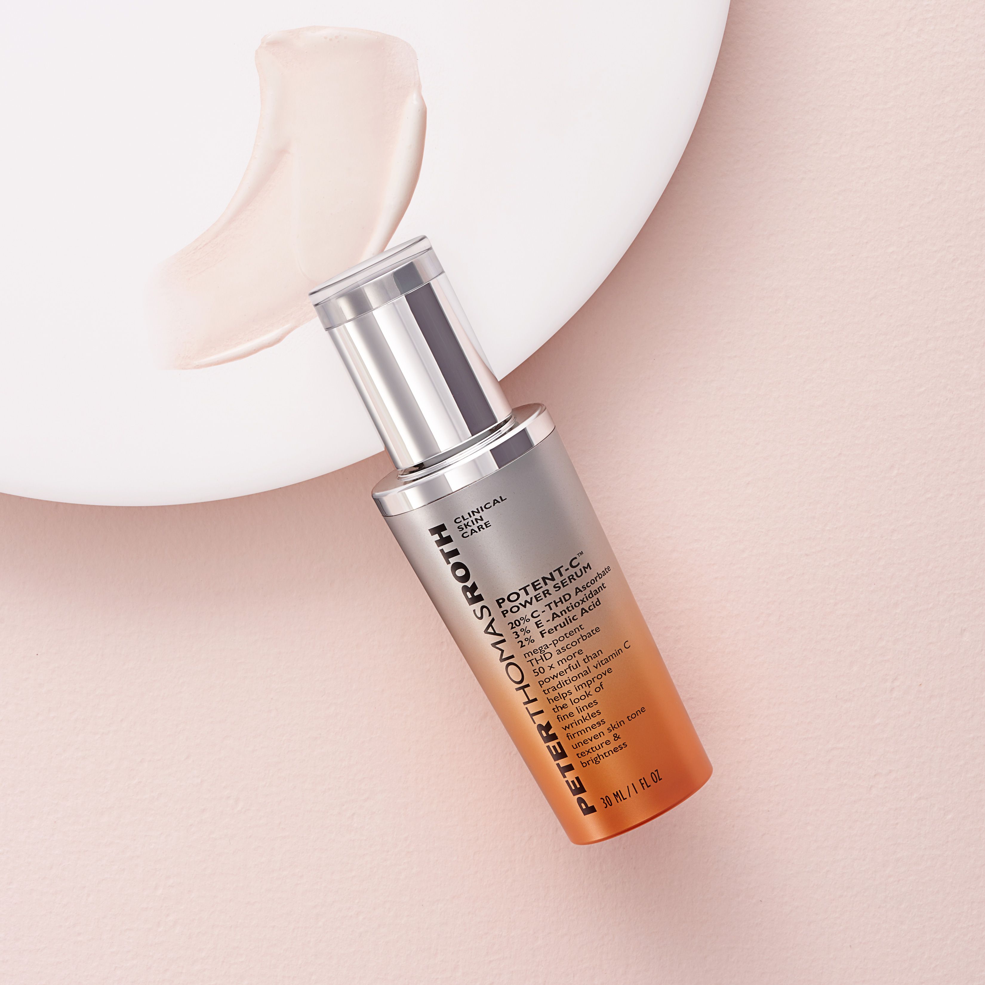 Flacone di siero su sfondo rosa. Accanto, una goccia di siero. Scritta: Potent-C Power Serum. Tappo argentato e sfumatura arancione.