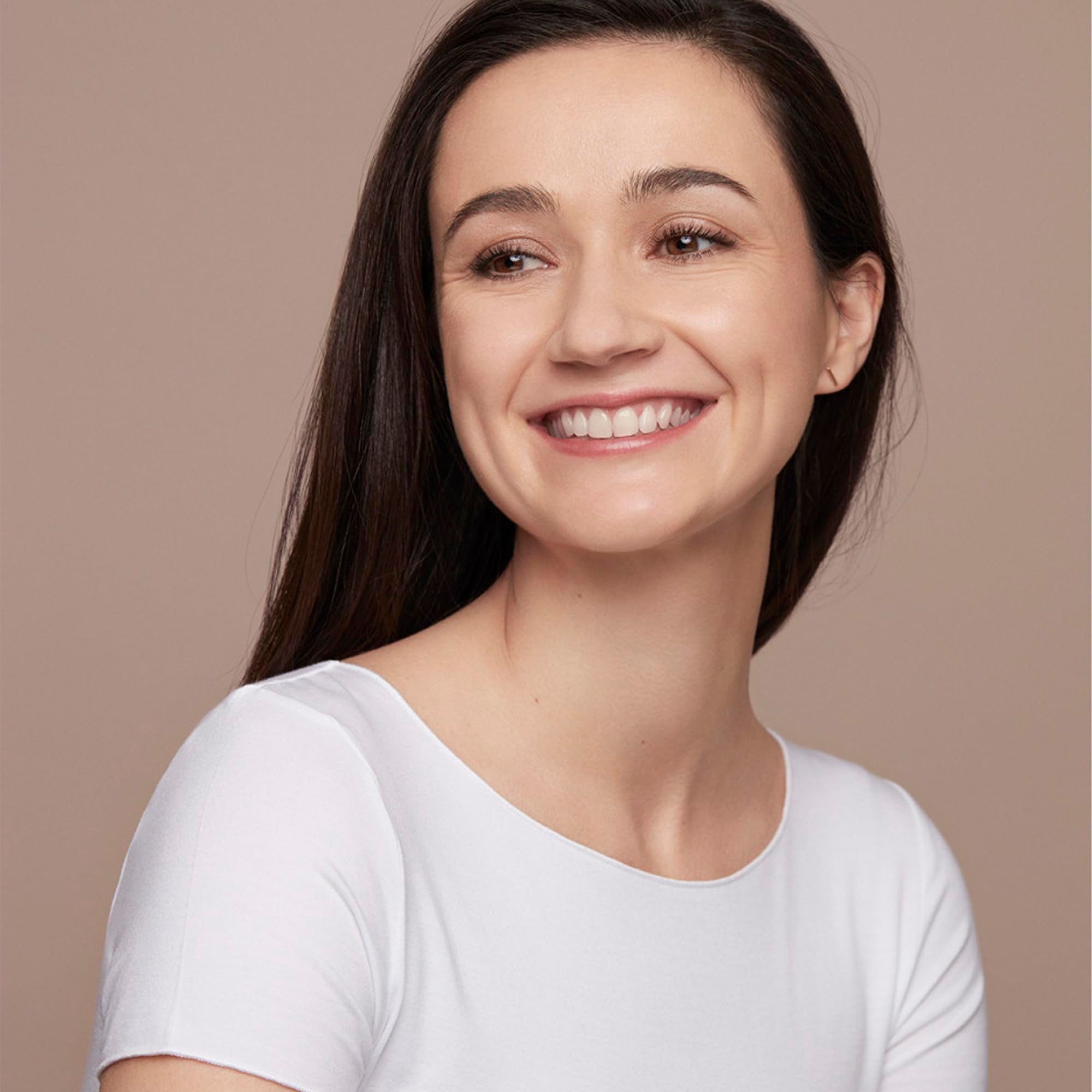 Ritratto di donna sorridente con lunghi capelli scuri. Indossa una maglietta bianca.