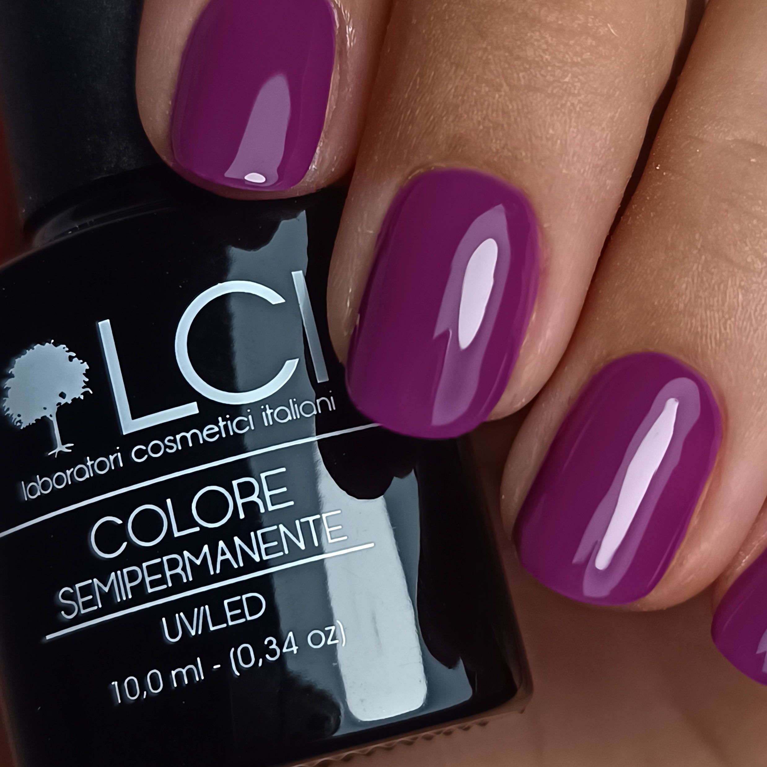 Mani con unghie laccate di viola. Accanto, flacone di smalto con scritta: LCI, Colore Semipermanente, UV/LED, 10,0 ml.