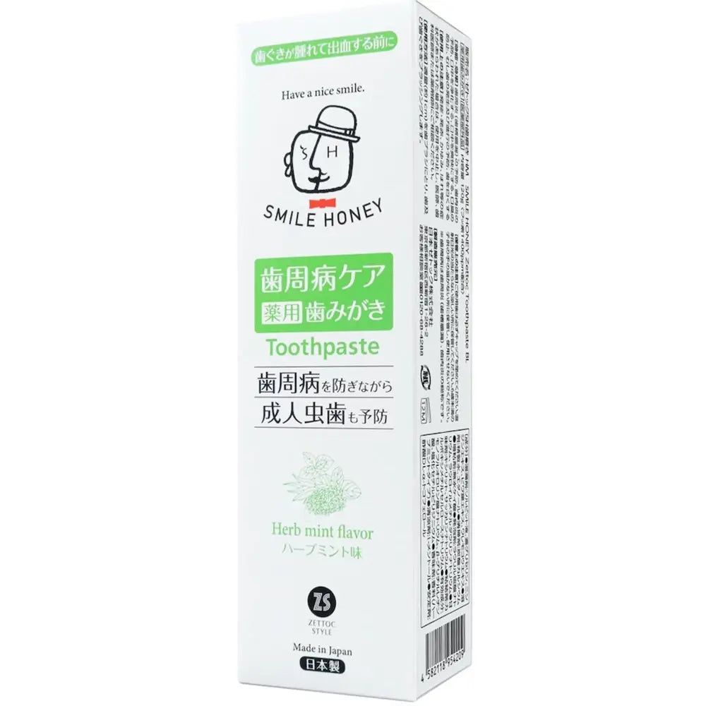 Confezione di dentifricio bianca, scritte verdi e nere. Scritta: SMILE HONEY, Toothpaste, Herb mint flavor.