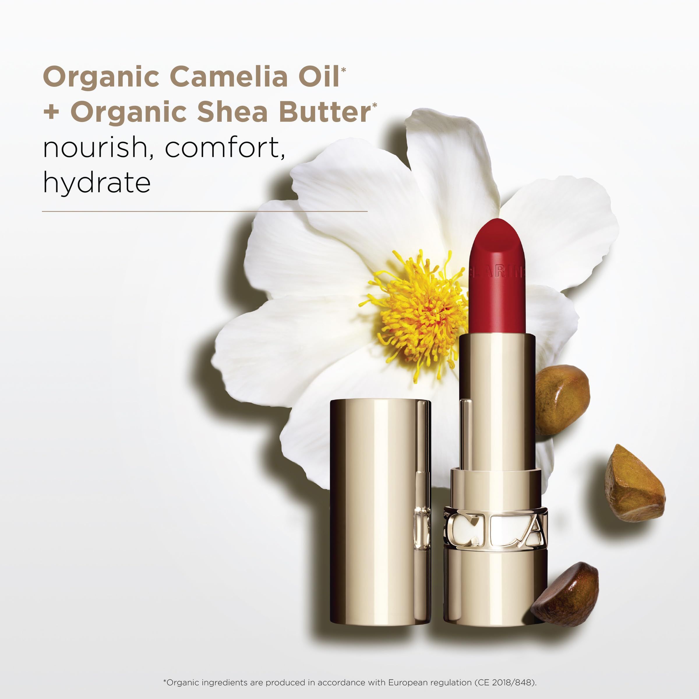Rossetto rosso in astuccio dorato, fiori e pietre. Testo: Organic Camelia Oil + Organic Shea Butter.