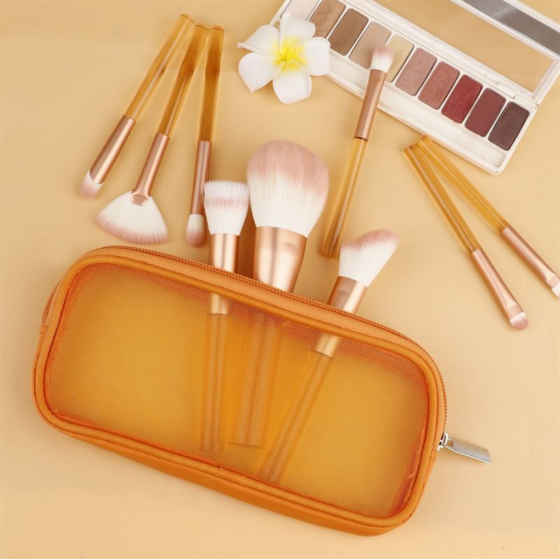 Set di pennelli per trucco con manici arancioni trasparenti, setole rosa, in una custodia arancione. Con palette.