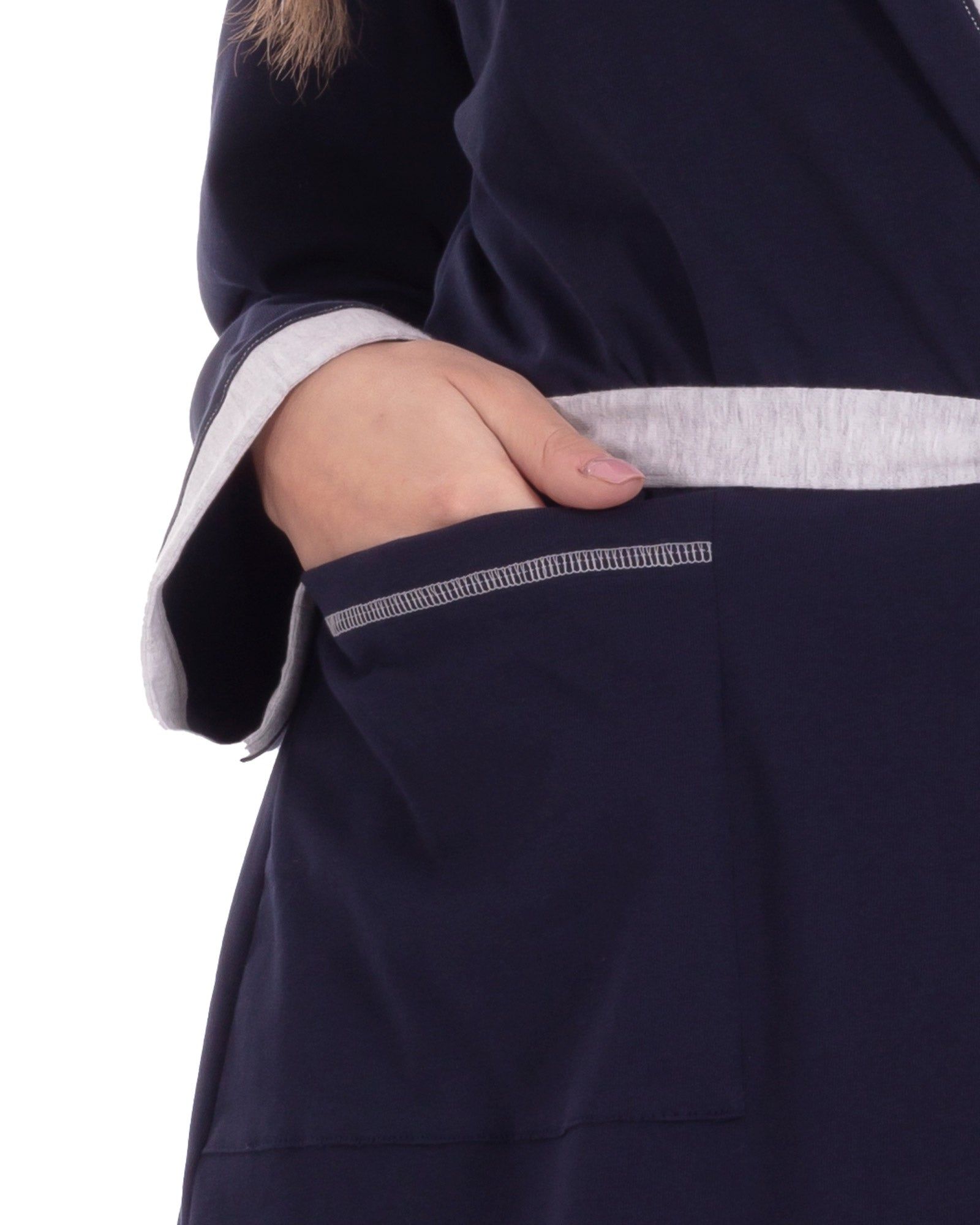 Dettaglio: tasca dell'accappatoio blu in cotone biologico. Bordi e cuciture grigie.