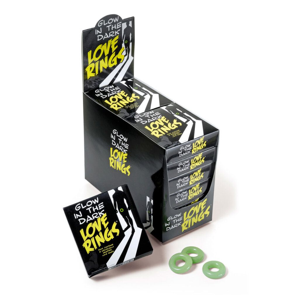 Espositore con scatole nere. Scritta: Glow in the Dark Love Rings. Tre anelli verdi accanto.