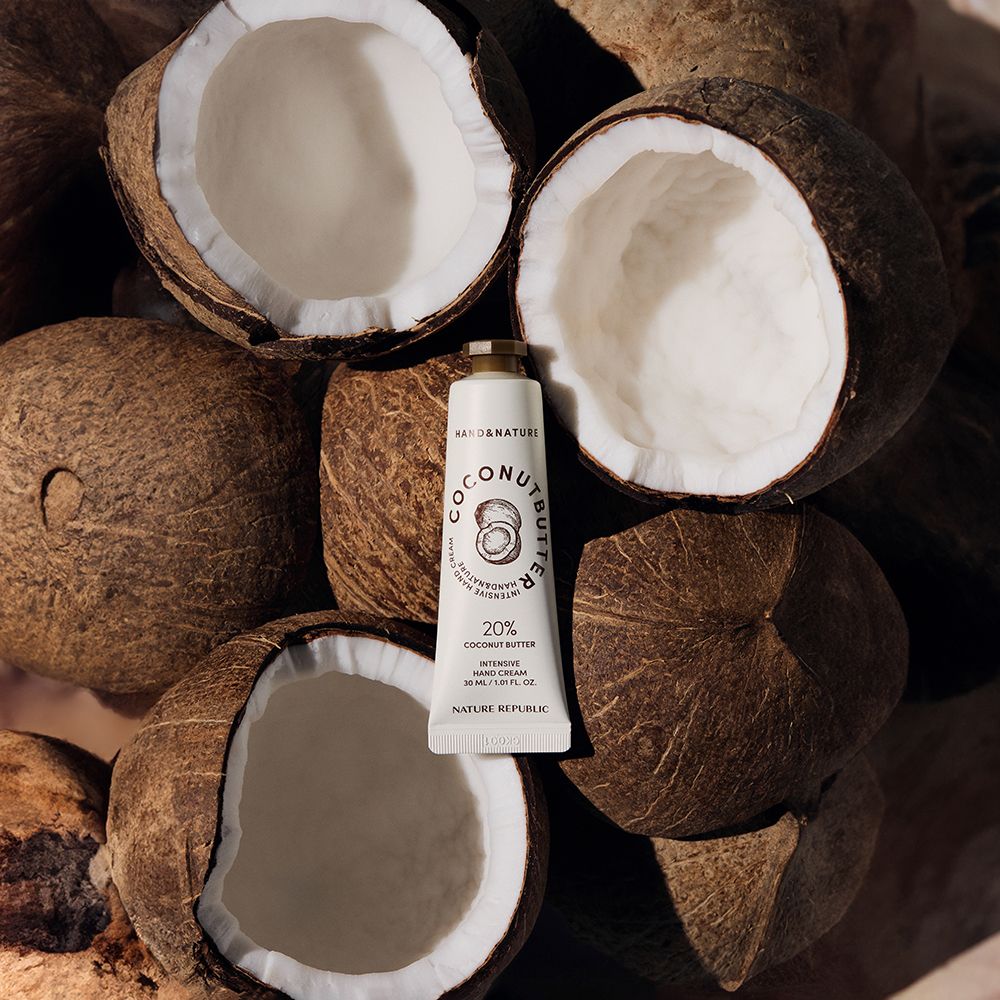 Tubo di crema mani su noci di cocco. Scritta: Coconut Butter, 20% Coconut Butter, Intensive Hand Cream. Marchio: NATURE REPUBLIC.
