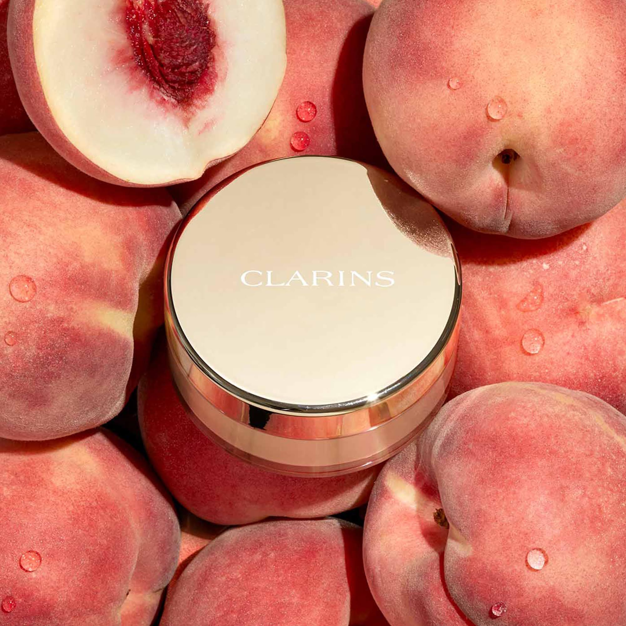 Clarins Ever Matte Loose Powder, tonalità 01. Contenitore dorato, circondato da pesche.