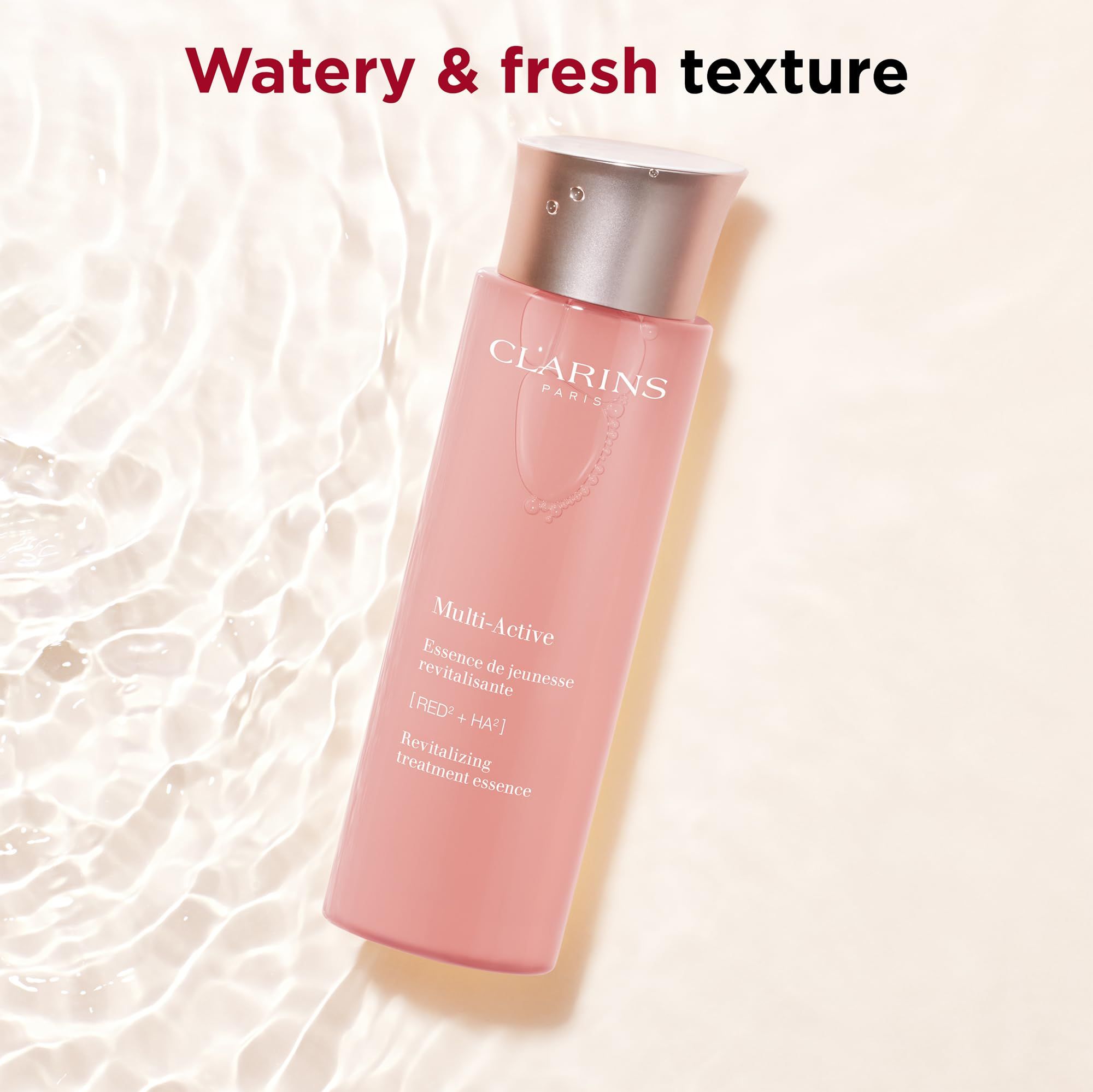 Essenza Clarins Multi-Active. Flacone rosa con tappo argento. Testo: Multi-Active, Revitalizing treatment essence. Sfondo: acqua.
