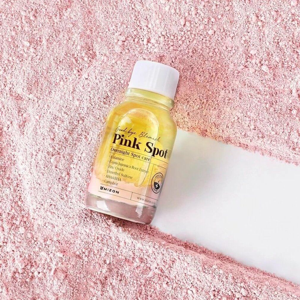 Flacone con liquido rosa su polvere rosa. Scritta: Good bye Blemish Pink Spot. Contiene ingredienti come la calamina.