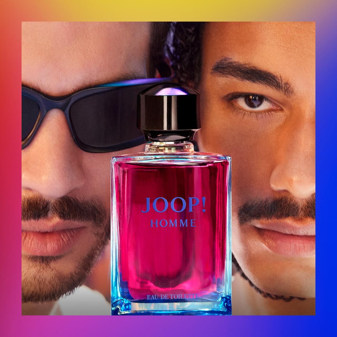 Flacone JOOP! Homme davanti a due uomini. Liquido rosa, tappo nero, scritta blu. Uomini sullo sfondo.