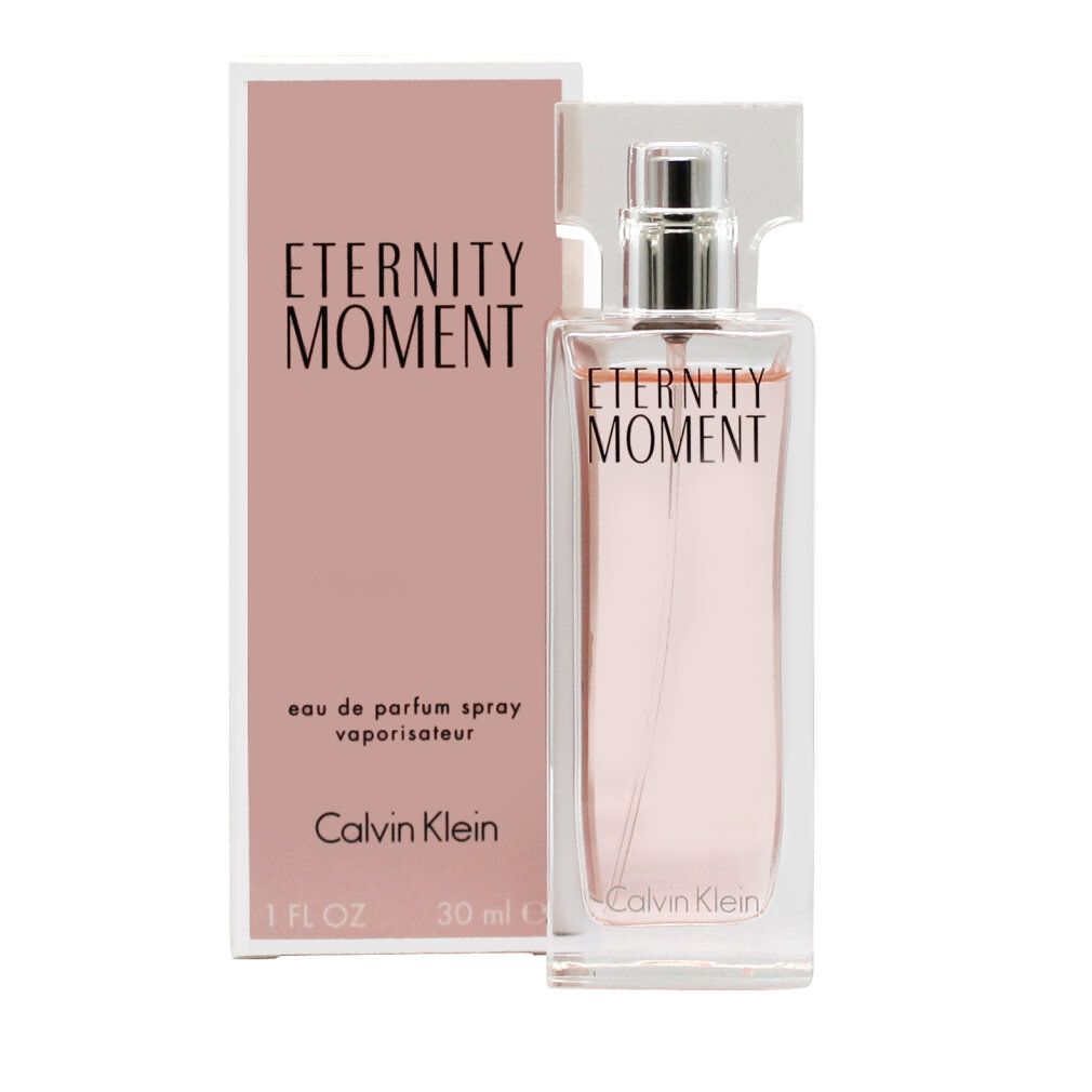 Flacone di profumo e confezione. Scritta "Eternity Moment" e "Calvin Klein". Liquido rosa in un flacone di vetro rettangolare.