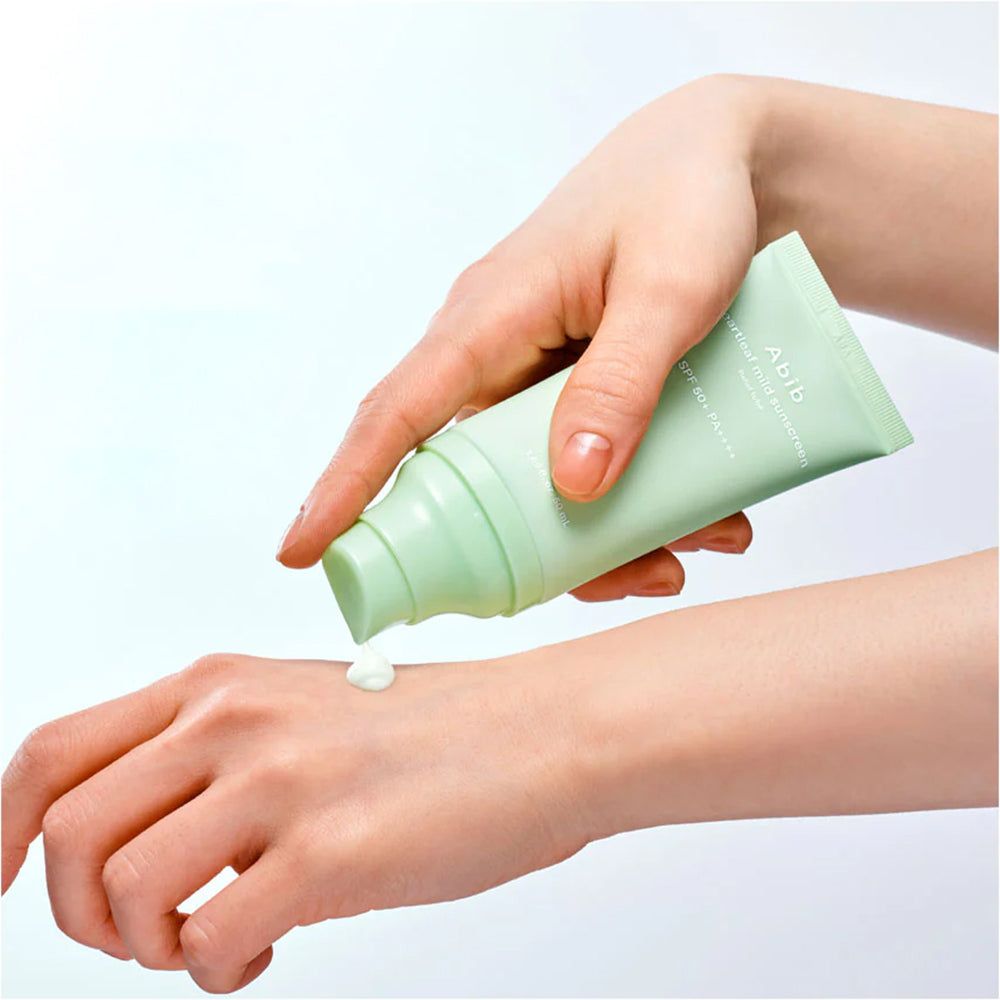 Una mano eroga la protezione solare Abib Heartleaf Mild SPF 50+ PA++++ su un'altra mano.