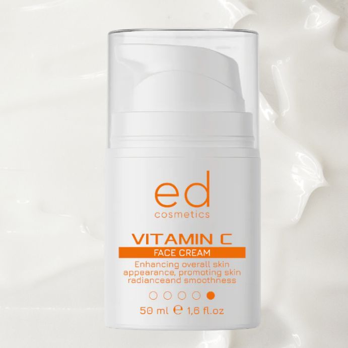 Flacone bianco con etichetta arancione. Testo: Vitamin C Face Cream, ed cosmetics. 50 ml. Su sfondo bianco.