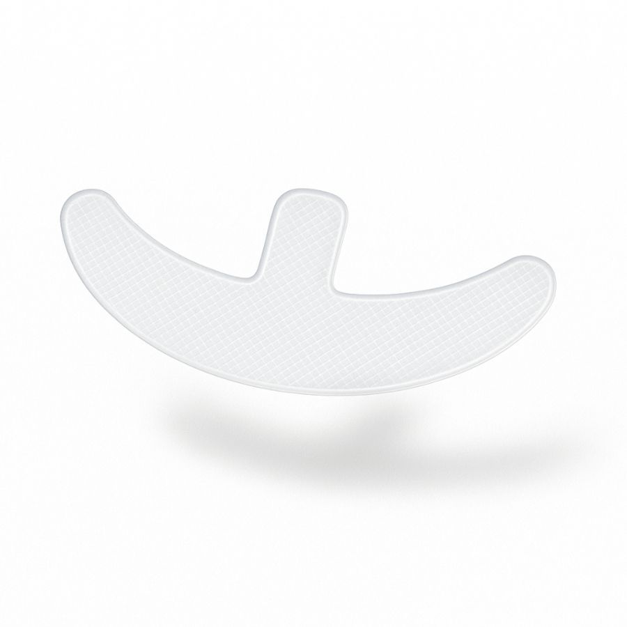 Cerotto in silicone trasparente a forma di mezzaluna con gambo centrale. Per la piega sottomammaria.