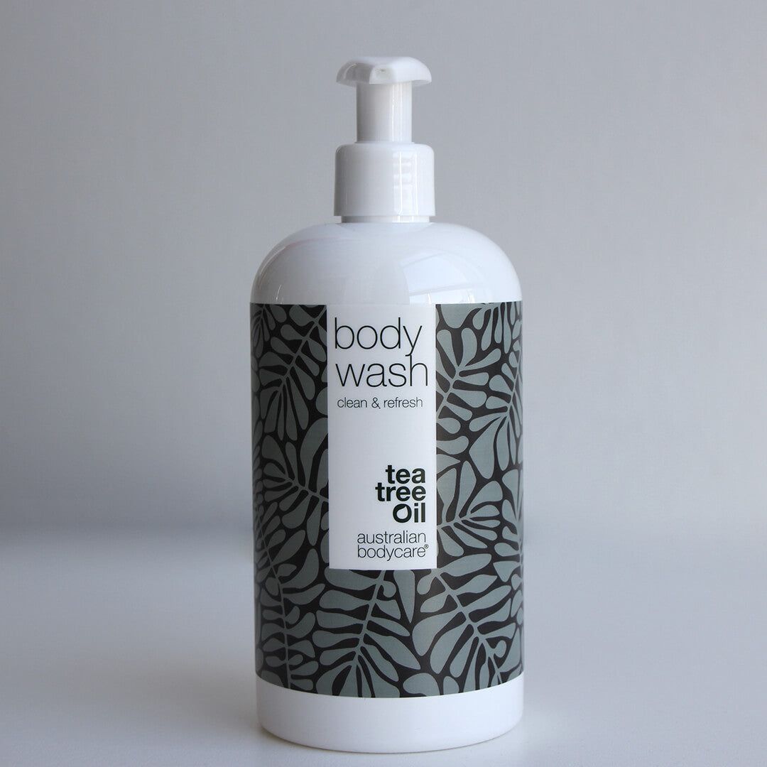 Flacone bianco di bagnoschiuma con pompa. Motivo a foglie grigie. Testo: Body Wash, Tea Tree Oil, Australian Bodycare.