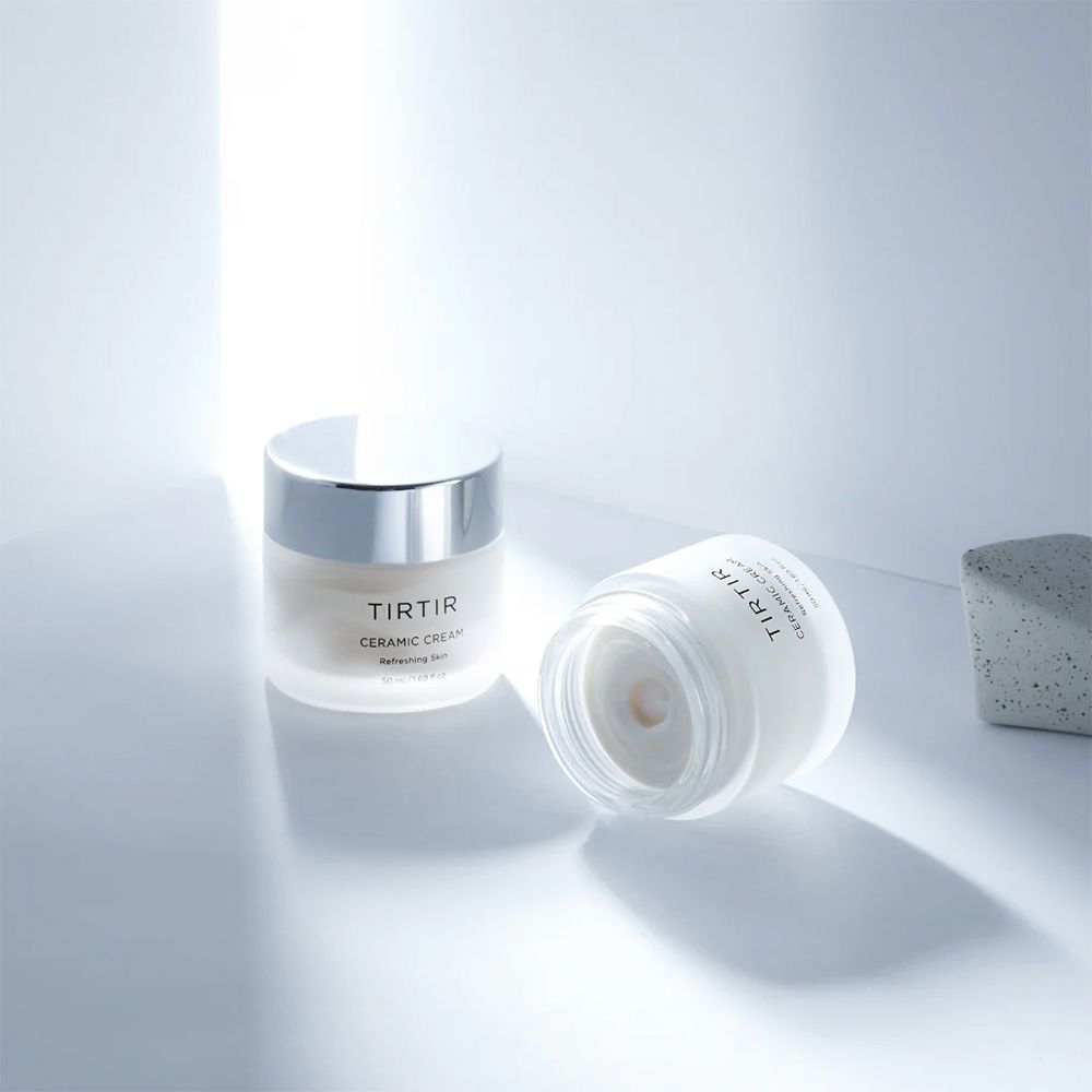 Due barattoli di Crema ceramica Tir Tir su una superficie chiara con effetti di luce.