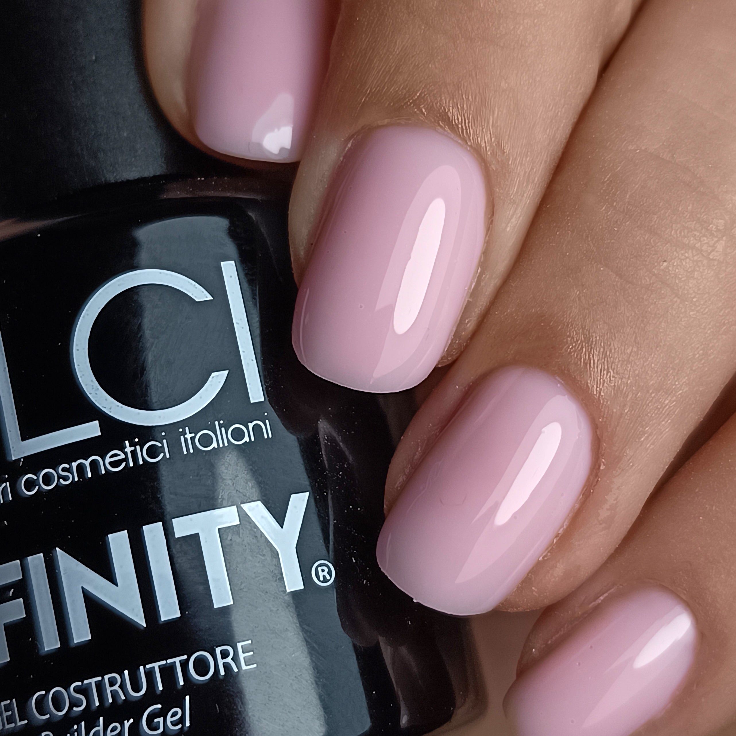Mano con unghie smaltate di rosa. Flacone nero con scritta LCI INFINITY Builder Gel.