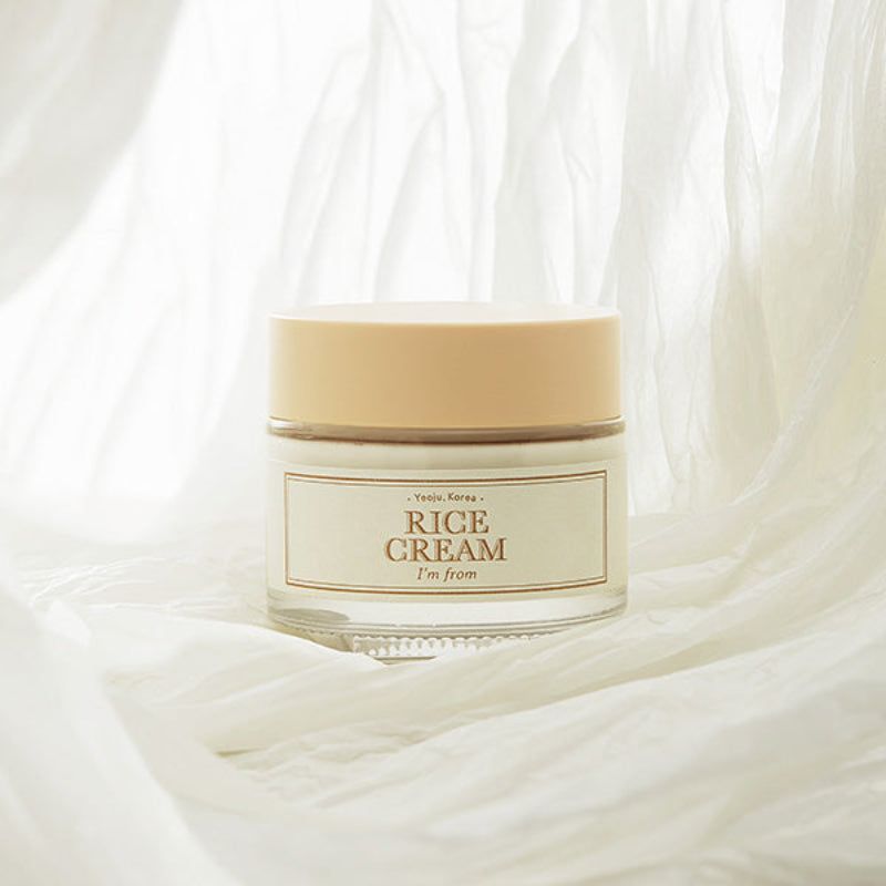 Vasetto di vetro con coperchio beige. Scritta: Rice Cream, I'M FROM. Su tessuto bianco.