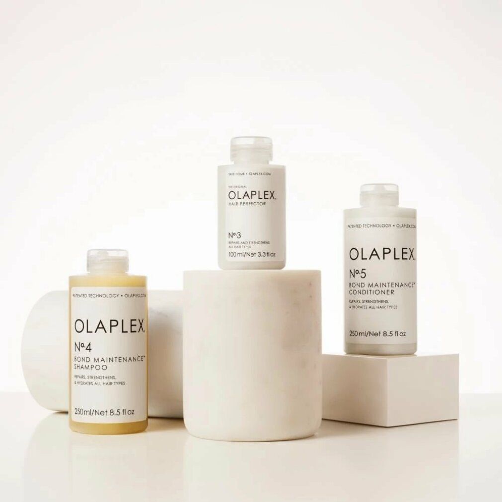 Tre prodotti Olaplex: Nº4, Nº3 e Nº5 Bond Maintenance Conditioner. Su piedistalli bianchi. Contiene 250 ml/8,5 fl oz. Ripara, rinforza e idrata.